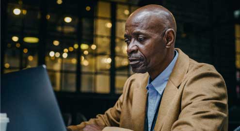 Man at his laptop searching for a job online.